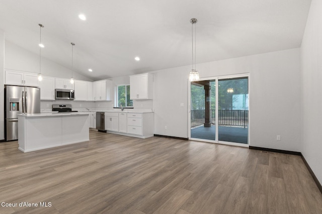 kitchen featuring stainless steel appliances, a kitchen island, pendant lighting, light hardwood / wood-style flooring, and white cabinetry