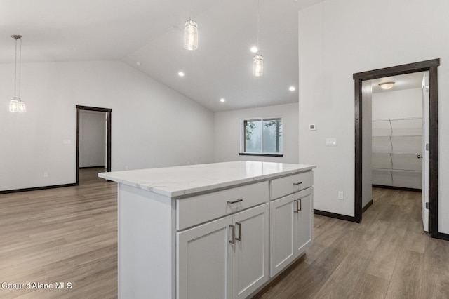 kitchen featuring a center island, white cabinets, pendant lighting, and light hardwood / wood-style flooring