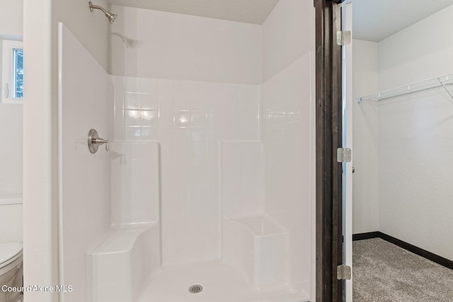 bathroom featuring a shower and toilet