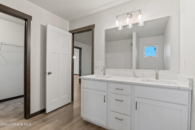 bathroom with a textured ceiling, vanity, and hardwood / wood-style flooring