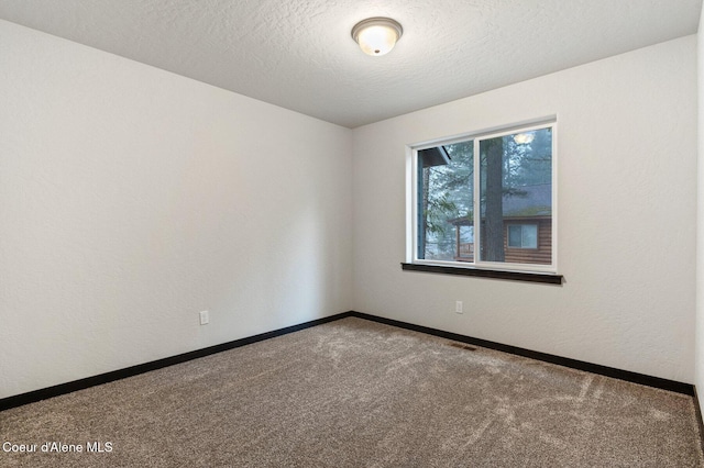 carpeted empty room with a textured ceiling