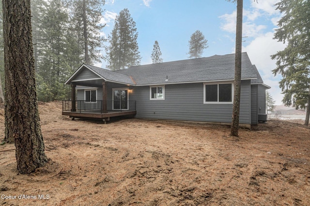 rear view of house with a wooden deck and central AC