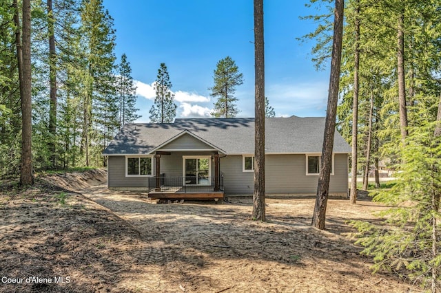 view of front of property with roof with shingles and a deck