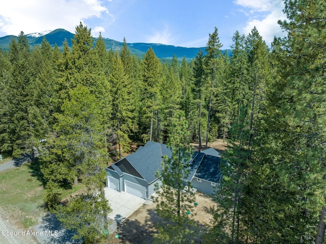 birds eye view of property featuring a forest view and a mountain view
