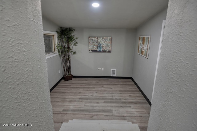 hallway with light hardwood / wood-style floors