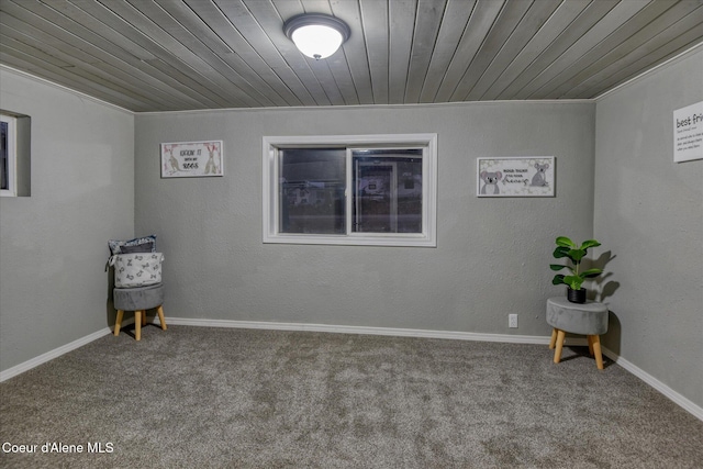 empty room featuring carpet flooring, wood ceiling, and ornamental molding