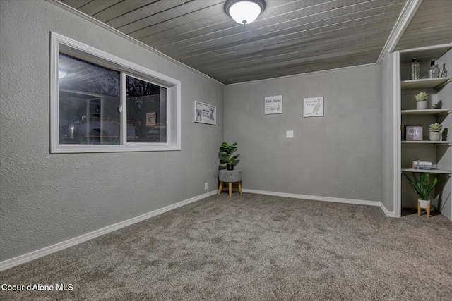 carpeted spare room with crown molding and wooden ceiling