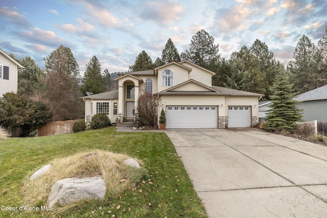 view of property featuring a garage and a front lawn