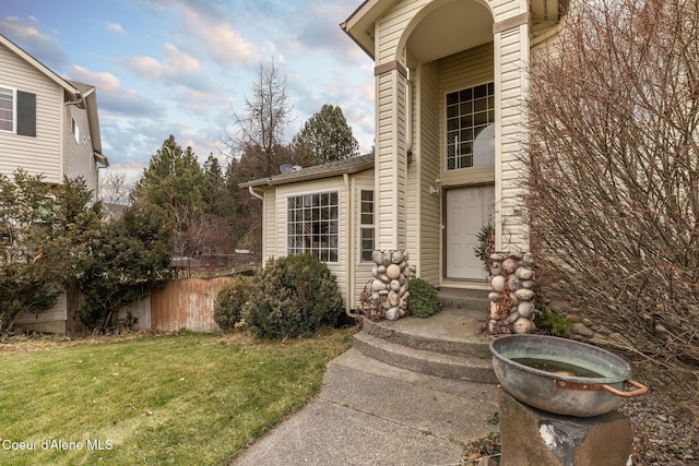 view of exterior entry featuring a lawn