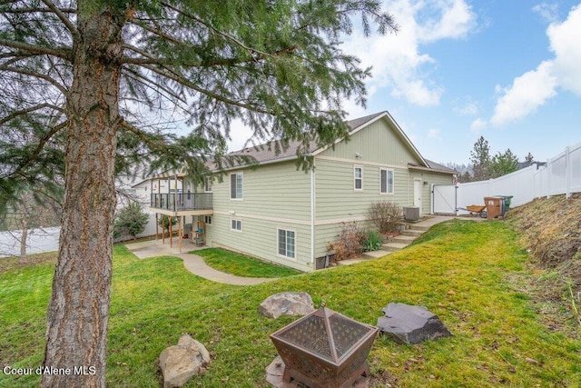 rear view of property with a yard, an outdoor fire pit, a patio area, and a wooden deck