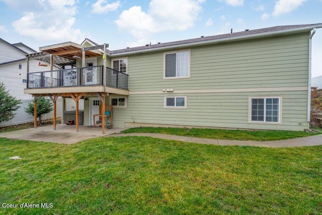 back of property with a deck, a hot tub, a patio area, and a lawn