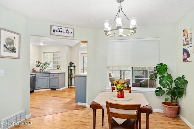 dining area with a chandelier and light wood-type flooring