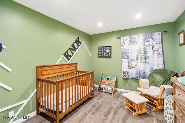 bedroom featuring light hardwood / wood-style floors and a crib