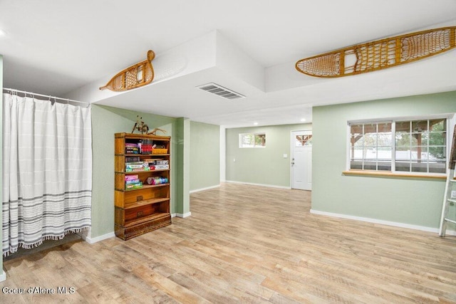 basement with light hardwood / wood-style flooring