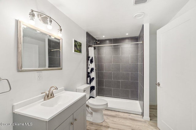 bathroom featuring toilet, hardwood / wood-style floors, vanity, and a shower with curtain