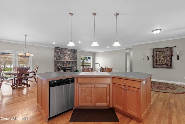 kitchen featuring light wood-type flooring, a center island, stainless steel dishwasher, and sink