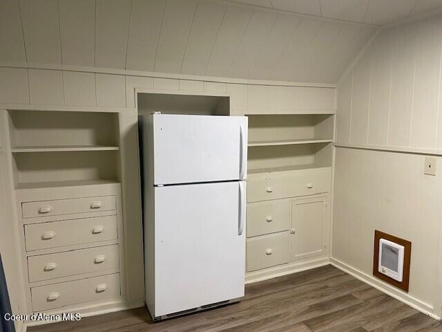 kitchen featuring wood walls, dark wood-type flooring, lofted ceiling, and white refrigerator