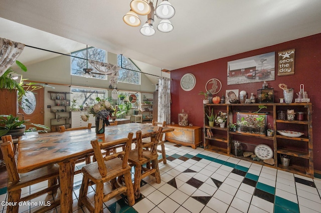 dining area featuring light tile patterned floors, ceiling fan with notable chandelier, and high vaulted ceiling