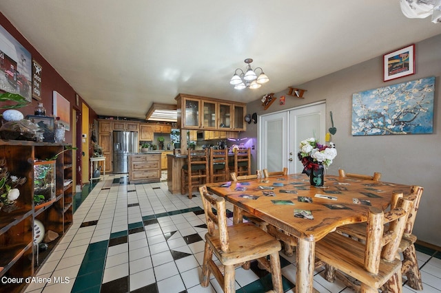 tiled dining space featuring french doors and an inviting chandelier