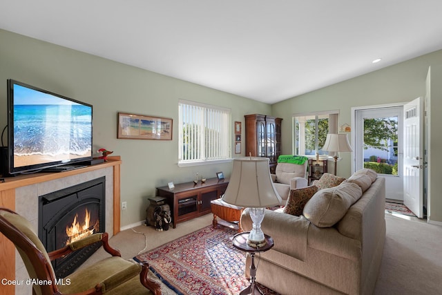 carpeted living room featuring a fireplace and vaulted ceiling