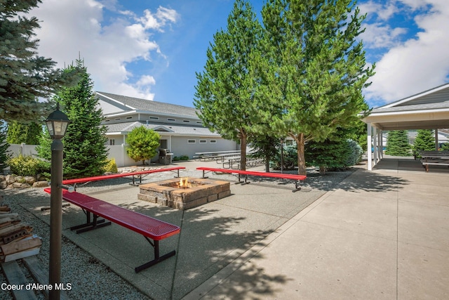 view of property's community with a patio area and a fire pit