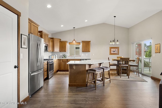 kitchen with dark hardwood / wood-style floors, a kitchen island, stainless steel appliances, and hanging light fixtures