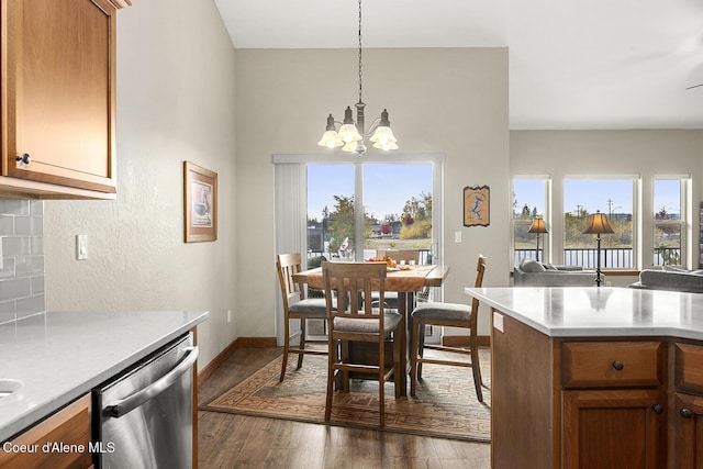 kitchen featuring hanging light fixtures, an inviting chandelier, tasteful backsplash, dark hardwood / wood-style flooring, and stainless steel dishwasher