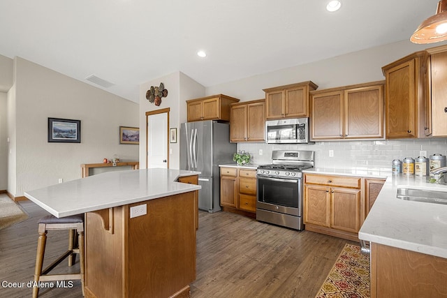 kitchen with stainless steel appliances, sink, dark hardwood / wood-style floors, a kitchen island, and lofted ceiling