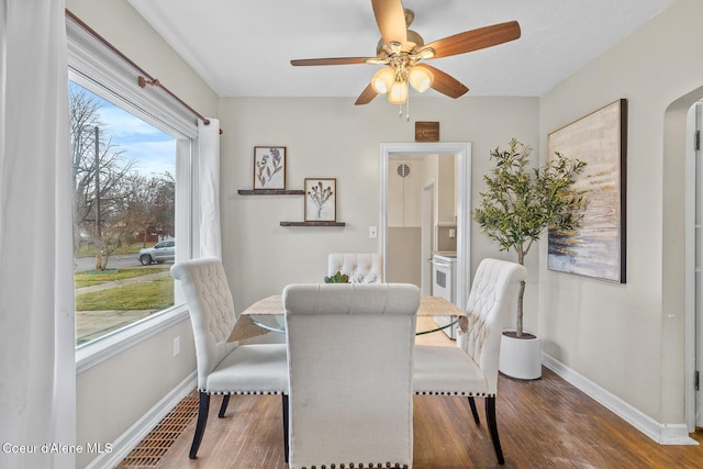 dining area with ceiling fan and dark wood-type flooring