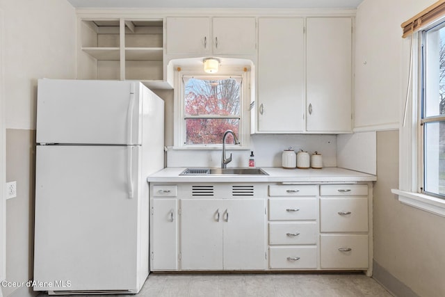 kitchen featuring white cabinetry, sink, and white refrigerator