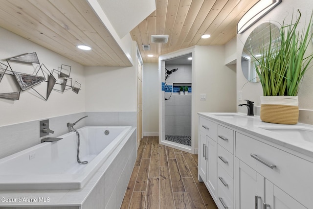 bathroom featuring wood-type flooring, vanity, and separate shower and tub