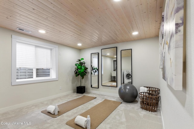 workout room featuring wood ceiling, washer / clothes dryer, and light colored carpet