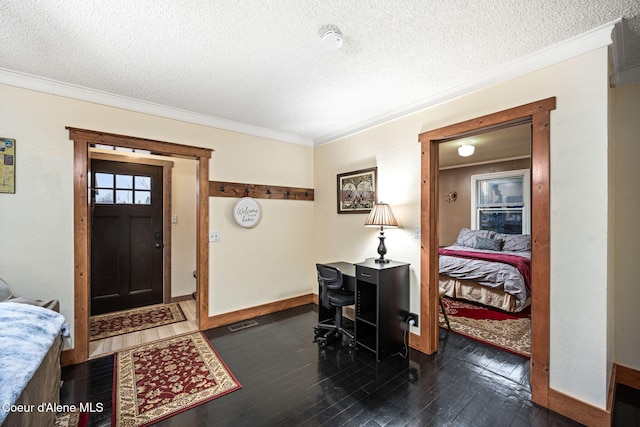 foyer with a textured ceiling, dark hardwood / wood-style floors, and ornamental molding