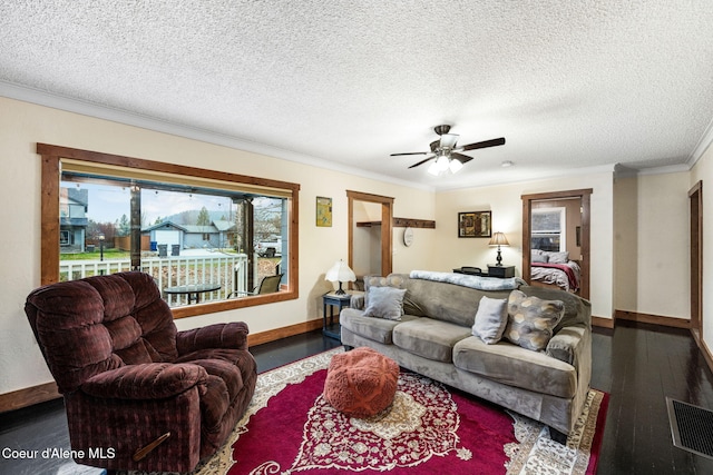 living room featuring a textured ceiling, ceiling fan, ornamental molding, and dark wood-type flooring