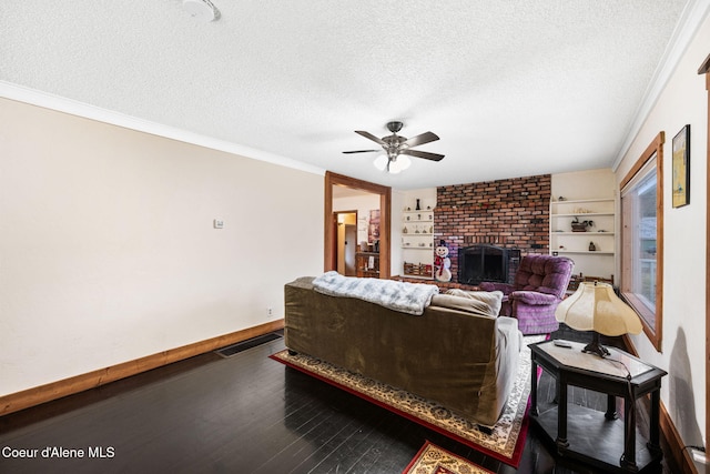 living room with hardwood / wood-style floors, a textured ceiling, and a brick fireplace