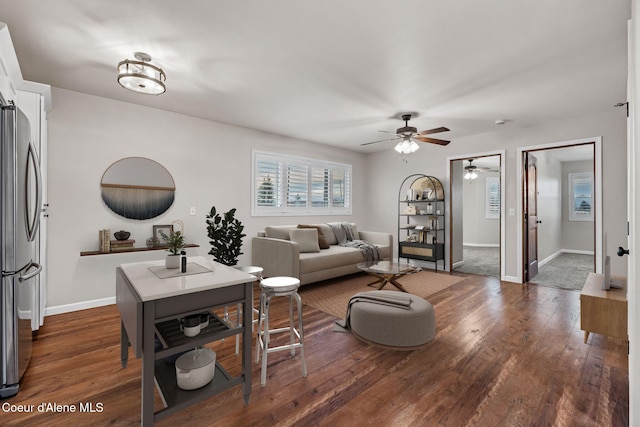 living room featuring ceiling fan and dark hardwood / wood-style flooring