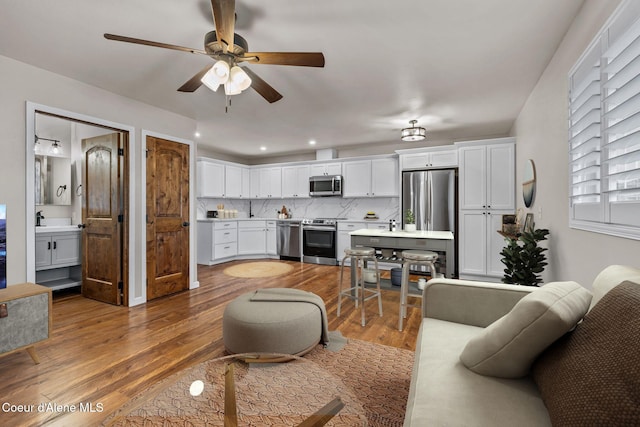 living room with ceiling fan and dark wood-type flooring