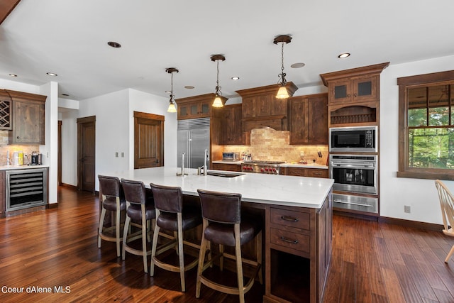6126 S Gozzer Rd, Harrison, ID 83833 - kitchen featuring decorative backsplash, dark hardwood / wood-style flooring, a spacious island, pendant lighting, and built in appliances