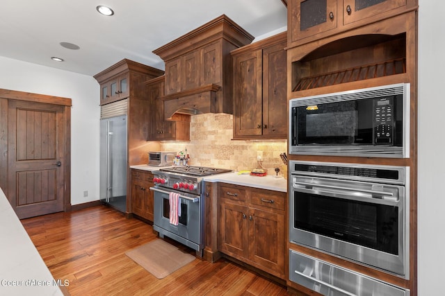 6126 S Gozzer Rd, Harrison, ID 83833 - kitchen with decorative backsplash, dark hardwood / wood-style flooring, built in appliances, and custom range hood