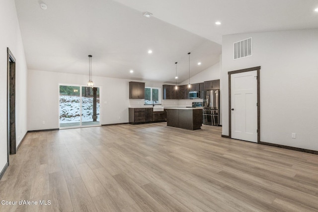 kitchen with decorative light fixtures, a center island, light hardwood / wood-style floors, and appliances with stainless steel finishes