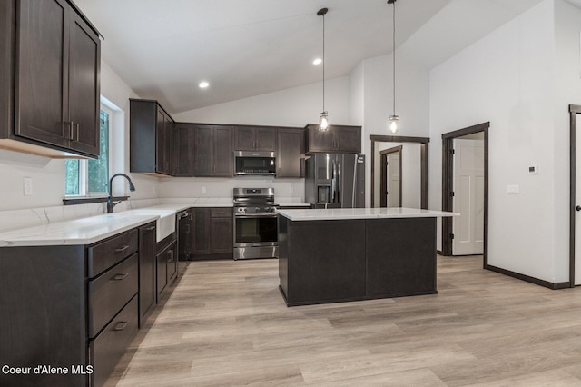 kitchen featuring a center island, sink, light hardwood / wood-style flooring, appliances with stainless steel finishes, and decorative light fixtures