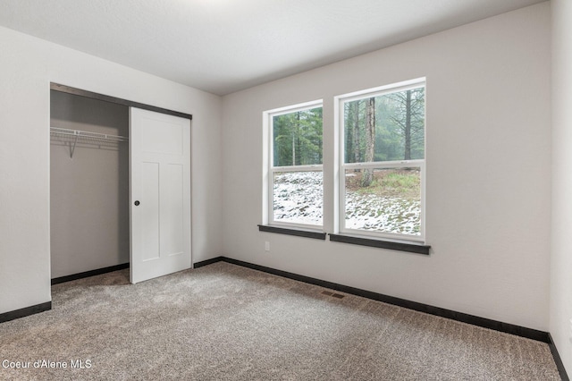 unfurnished bedroom with a closet and carpet floors