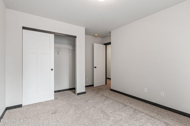 unfurnished bedroom featuring light colored carpet and a closet