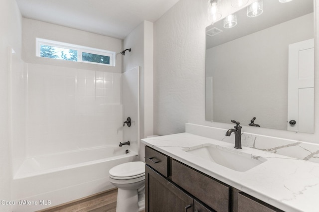 full bathroom featuring hardwood / wood-style floors, vanity, toilet, and bathtub / shower combination