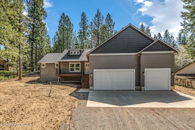 craftsman house featuring a garage, covered porch, and concrete driveway