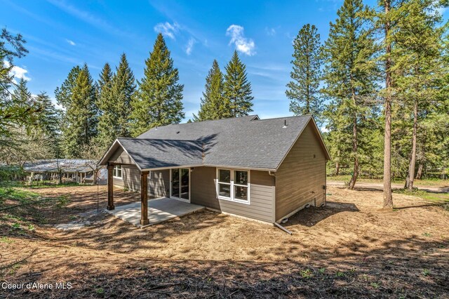 back of house featuring a shingled roof and a patio area