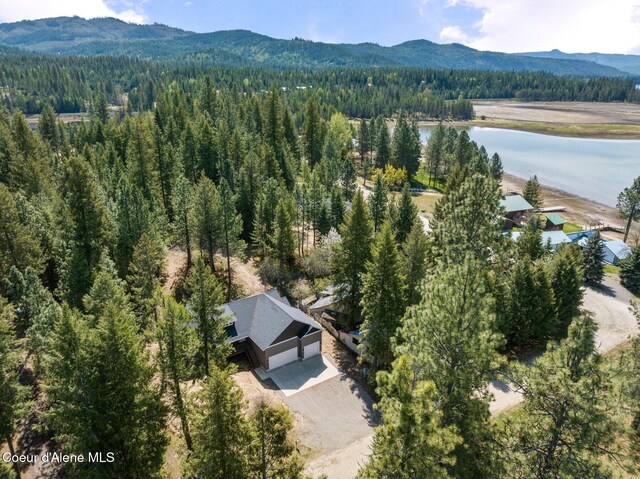 aerial view featuring a view of trees and a water and mountain view