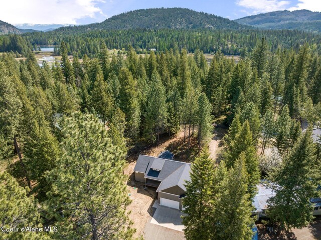 birds eye view of property with a wooded view and a mountain view