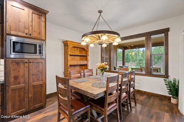 dining area with dark hardwood / wood-style flooring and a chandelier