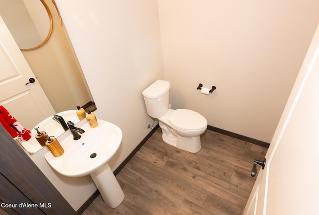 bathroom with sink, toilet, and hardwood / wood-style flooring